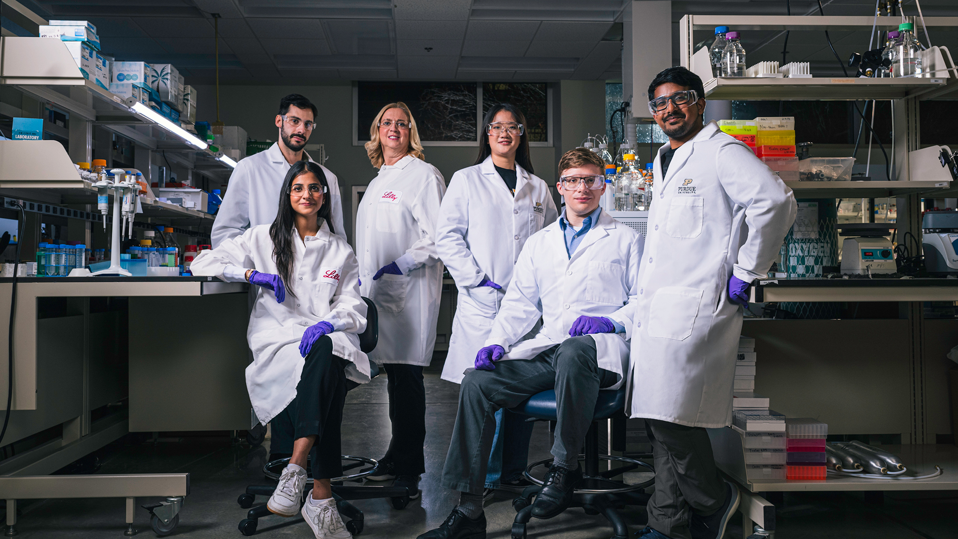 Purdue researchers and students in lab gear in a lab.