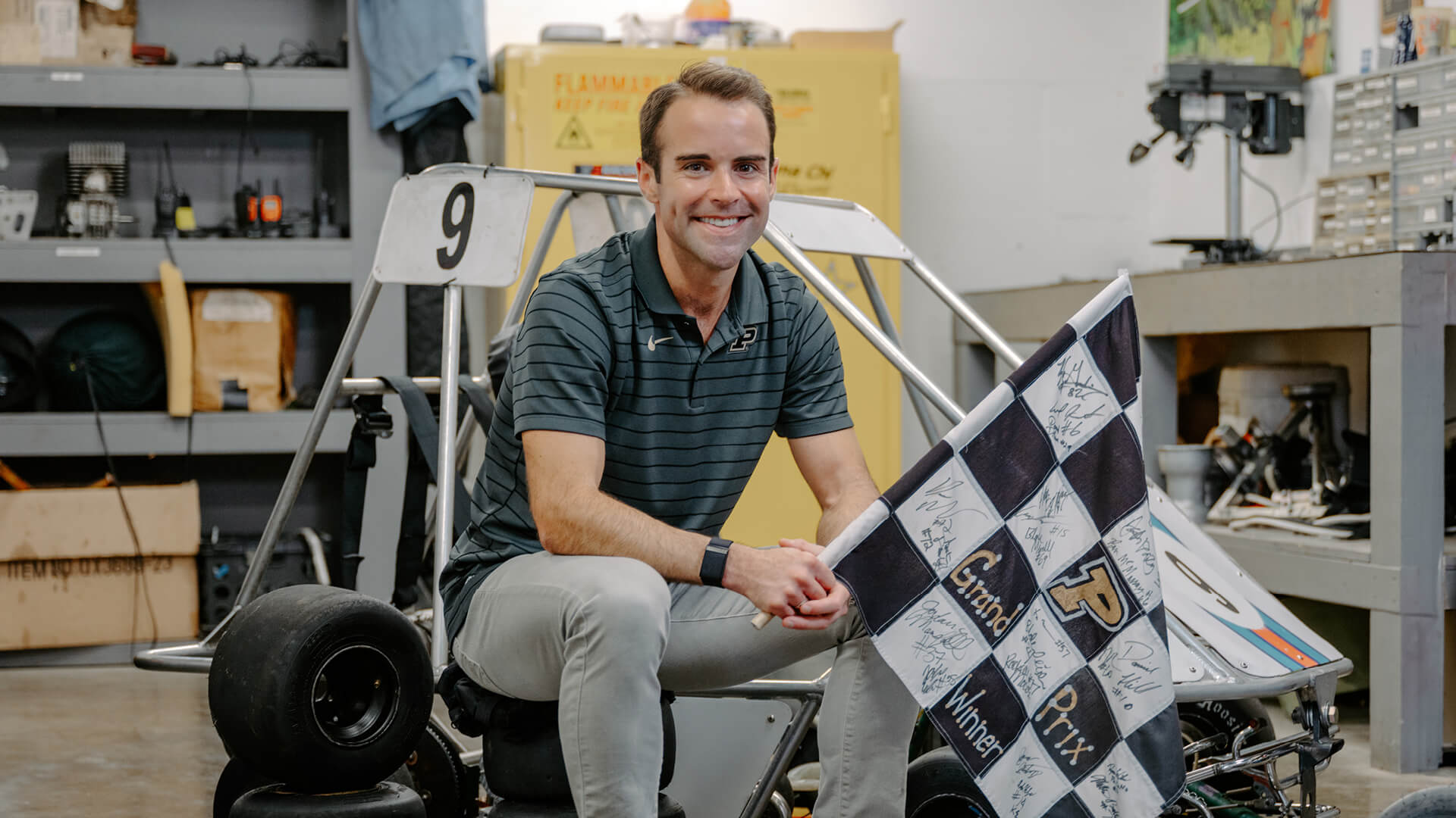 Travis Iles sits on a go-kart in the Sigma Chi garage